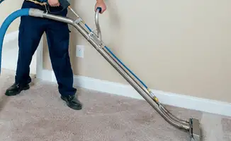 Professional operating a liquid removal machine on a carpeted floor in Phoenix, AZ